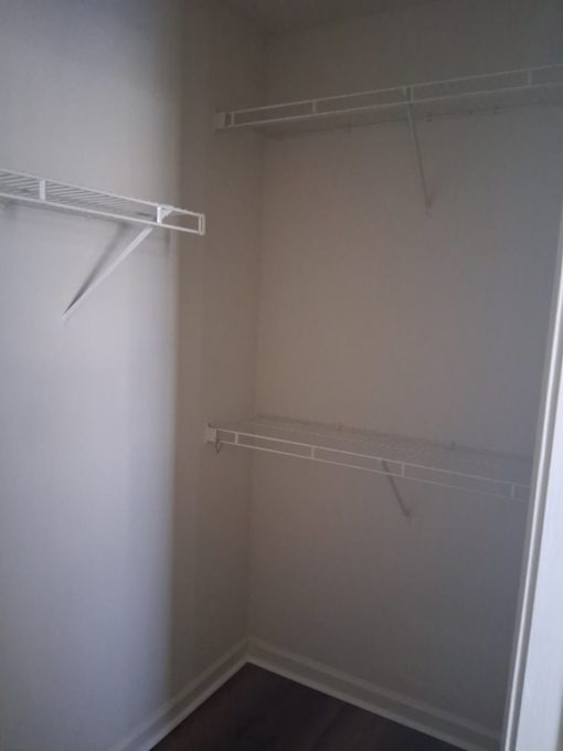 A white closet with two shelves.