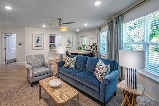A living room with a blue couch and a grey armchair.