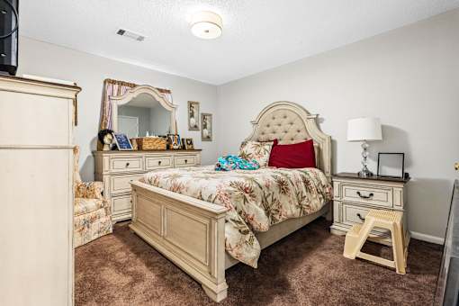 A bedroom with a large bed and a vanity table.
