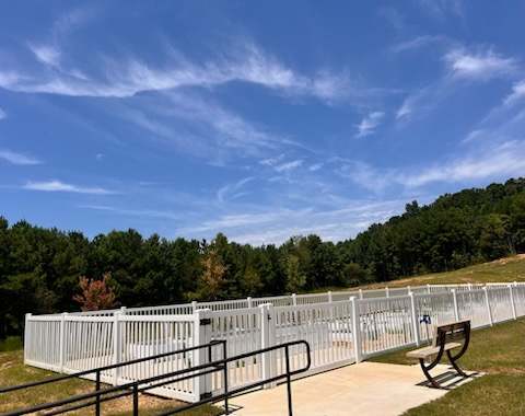 A white fence with a bench in front of it.