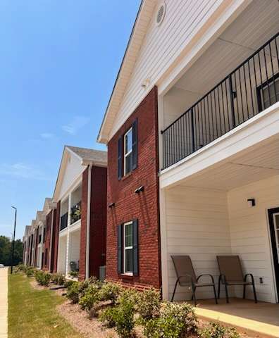 A row of red brick houses with white trim and black railings.