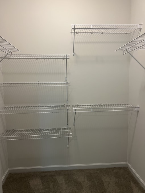 a walk in shower with a glass door and white walls