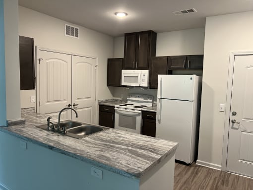 a kitchen with a white refrigerator freezer next to a stove top oven