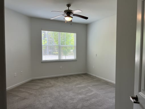 a bedroom with a ceiling fan and a window