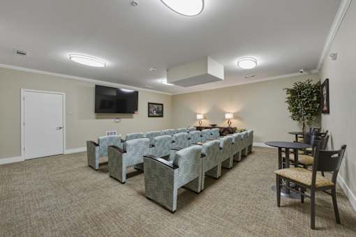 A room with a carpeted floor and a long table with chairs on it.