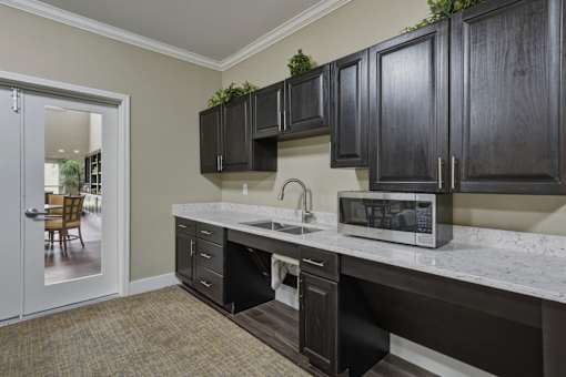 A kitchen with black cabinets and a white counter top.