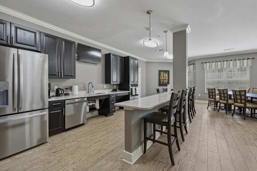 A kitchen with a large island and wooden floors.