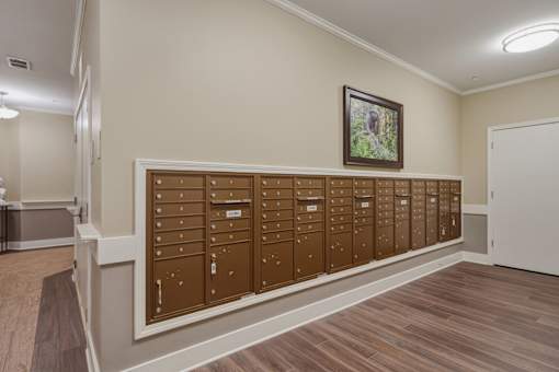 A row of brown mailboxes are lined up on a wall.