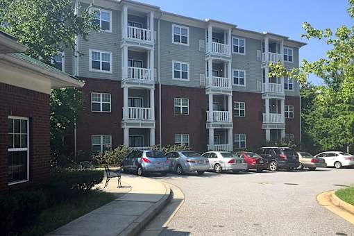 A parking lot with cars and a building in the background.