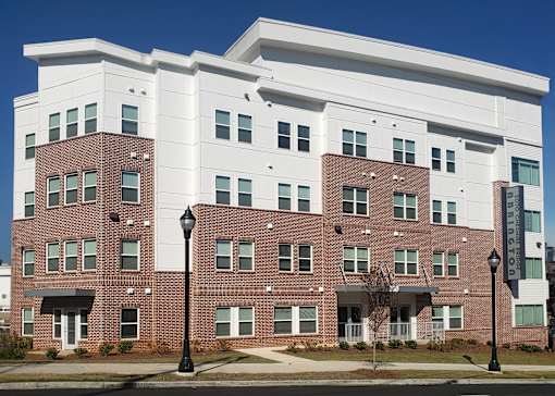 A large brick building with a white section on the top floor.