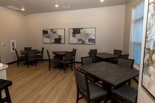 A room with a table and chairs and two pictures on the wall.