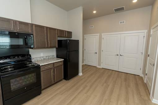 A kitchen with black appliances and wooden cabinets.