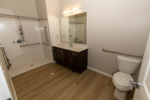A small bathroom with a toilet, sink, and shower.