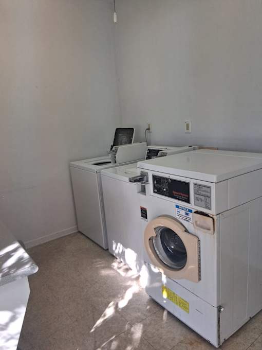A white washing machine and dryer in a laundry room.
