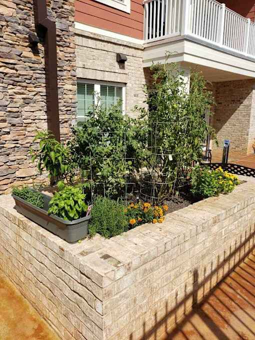 A stone wall with a planter box on top.