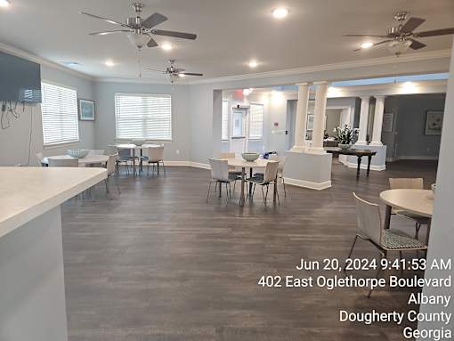 A spacious room with tables and chairs is shown with a timestamp and location information.