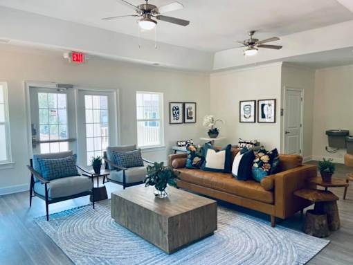 A living room with a brown couch, two chairs, and a coffee table.