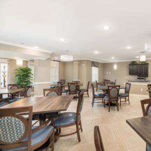A dining room with wooden furniture and a television mounted on the wall.