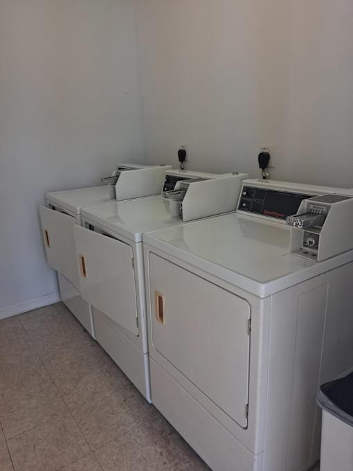 A white washing machine and dryer in a room.