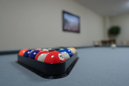 A pool table with a red, white and blue ball on it.