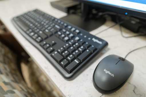 A black keyboard and mouse are on a desk.