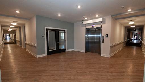 A hallway with wood floors and a stair lift.