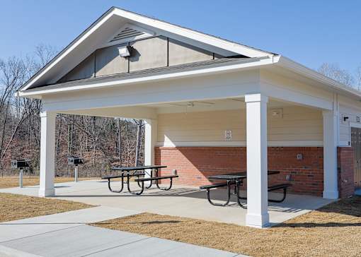 A covered picnic area with a table and chairs.