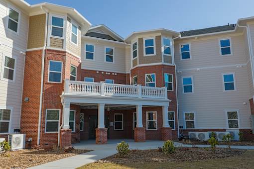 A large multi-story apartment building with a central courtyard.