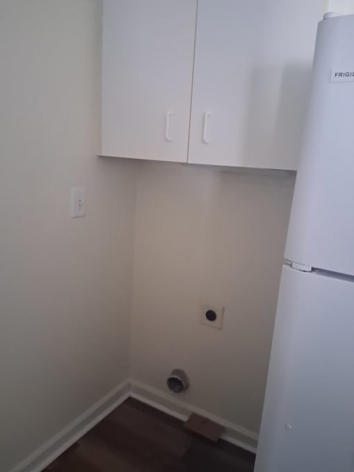 A white refrigerator sits in a kitchen corner.