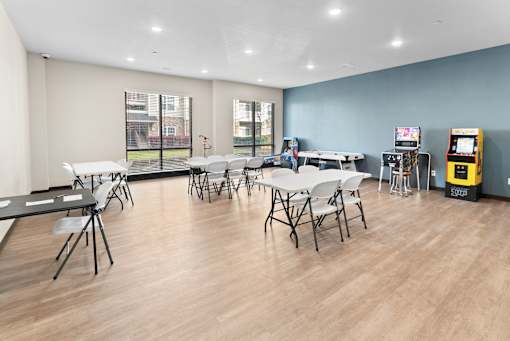 A room with tables and chairs and a vending machine.