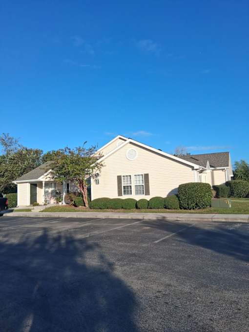 A small building with a parking lot in front.