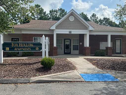 A small building with a porch and a sign that says "Lake".