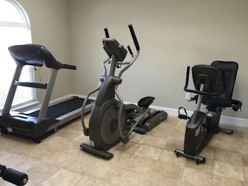 Three exercise machines are in a room.