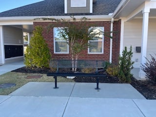 A brick house with a bench in front of it.