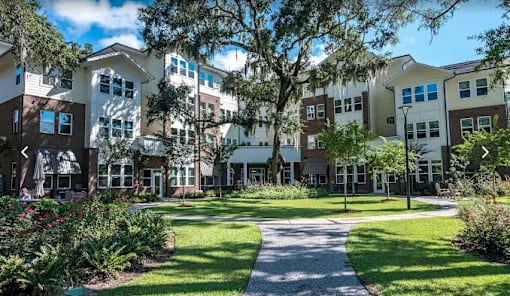 A sunny day at a residential complex with a pathway and greenery.