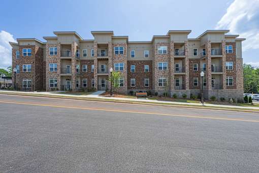 A large apartment building with a parking lot in front.