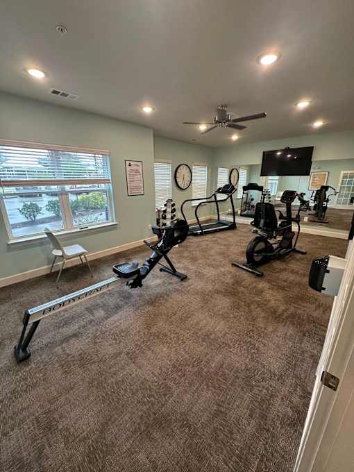 A spacious home gym with exercise equipment and a television.