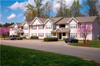 A large building with a green lawn in front.