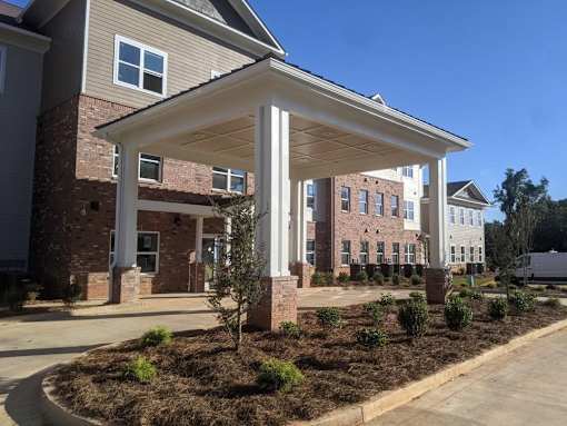 A covered walkway leads to a building with a brick facade.