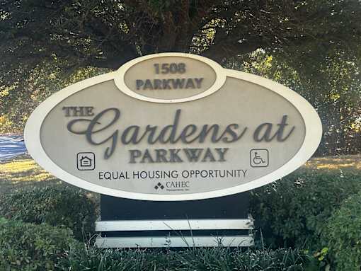 A sign for The Gardens at Parkway reads 1508 Parkway.