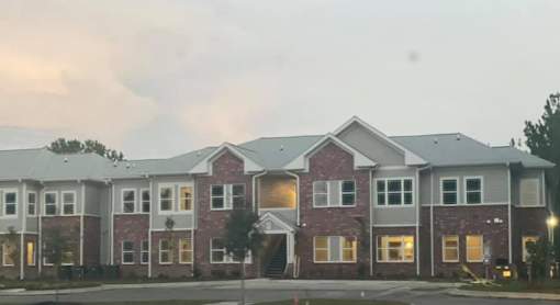 A row of houses with a cloudy sky in the background.