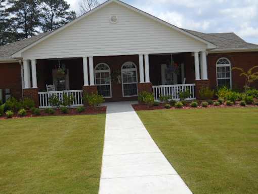 A white house with a porch and a walkway leading to the front door.