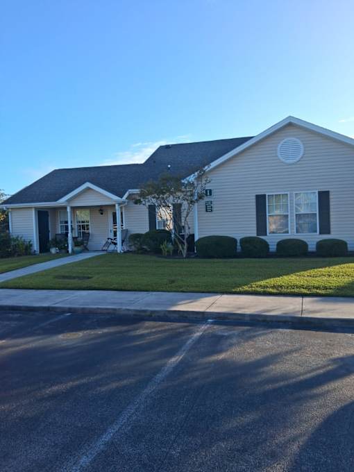 A house with a white front porch and a tree in front.