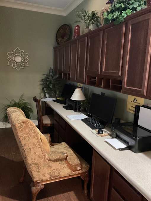 A brown chair sits in front of a desk with a computer on it.