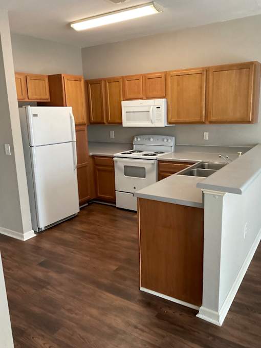 A kitchen with wooden cabinets and a white refrigerator.