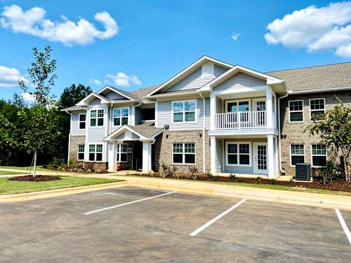 A large two-story building with a parking lot in front.