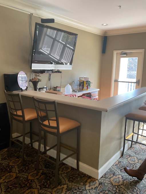 A bar area with two chairs and a television.