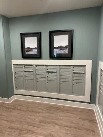 A wall with two pictures and a row of drawers below it.