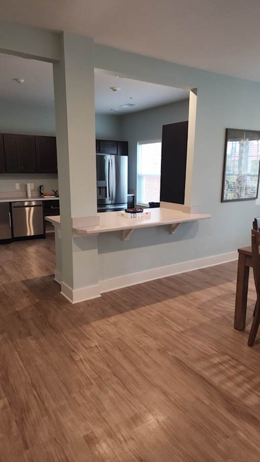 A kitchen with a wooden floor and a white counter.
