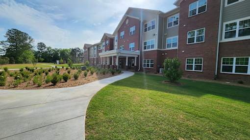 A long building with a grassy area in front.